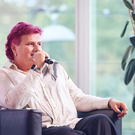zur Seite: Keynotes & Impulse Lena sitzend, spricht in Mikrofon
